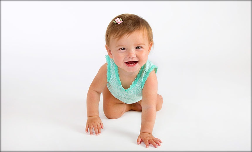 Toddler on hands and knees on a white background