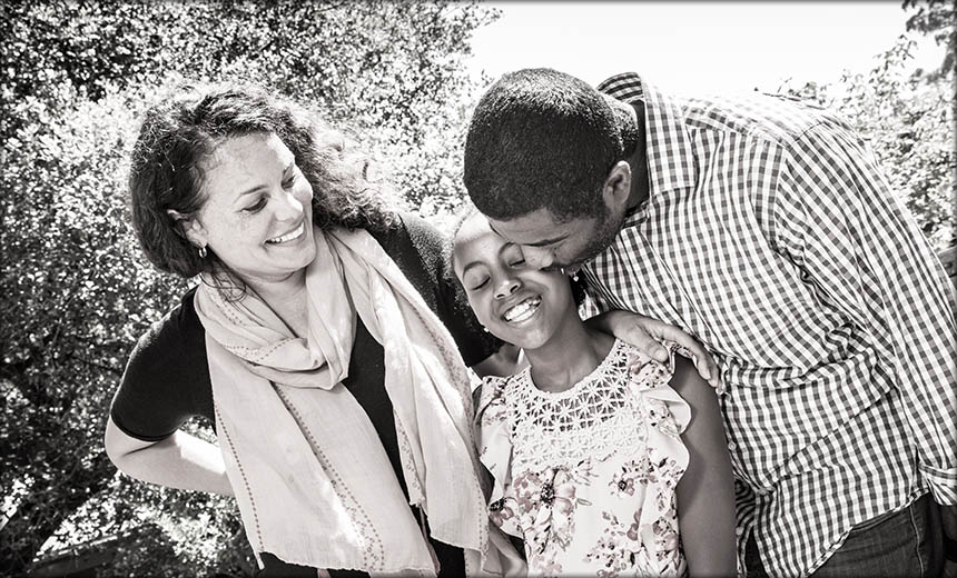 sepia family portrait of mom dad and daughter