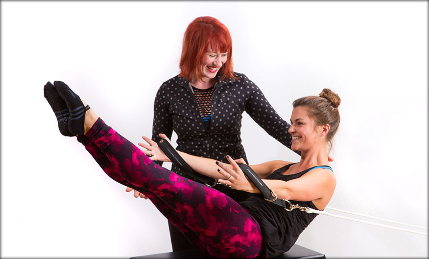 Pilates trainer assisting a student