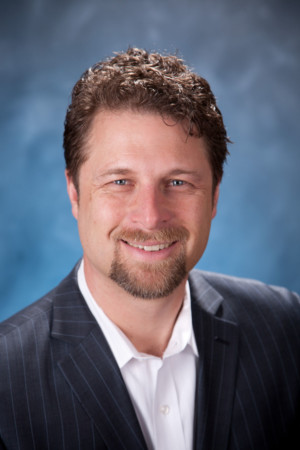 Man with goatee on mottled blue backdrop