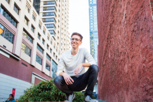Millennial poses crouching with SF cityscape