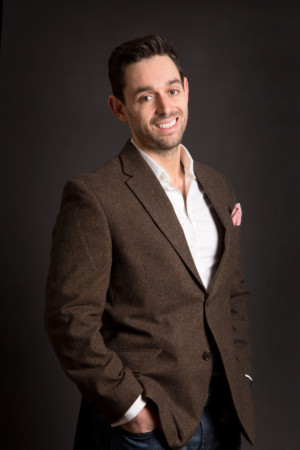 Stylish man in brown suit on black backdrop